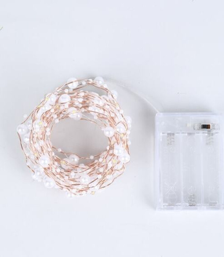 Rommet er dekorert med perler, juletrelys og kobber